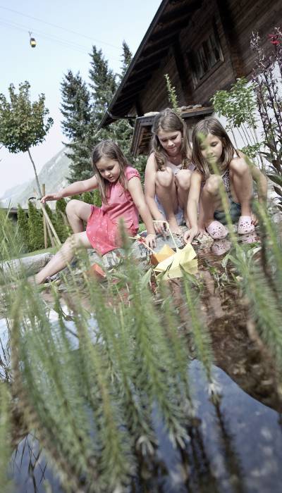 Mädchen spielen am Wasser; BRUGGER ChaletDorf Mayrhofen