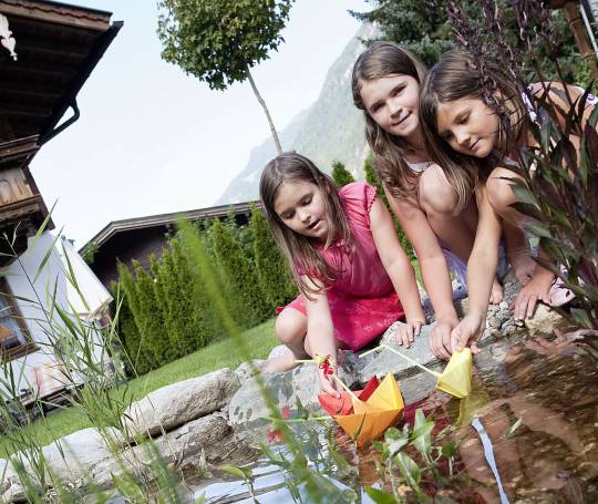 Mädchen spielen am Wasser im BRUGGER ChaletDorf Mayrhofen