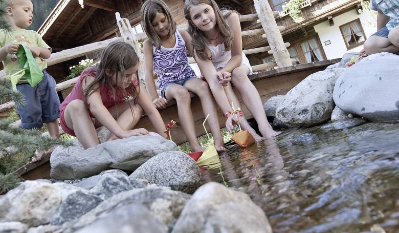 Kinder spielen am Wasser BRUGGER ChaletDorf Mayrhofen